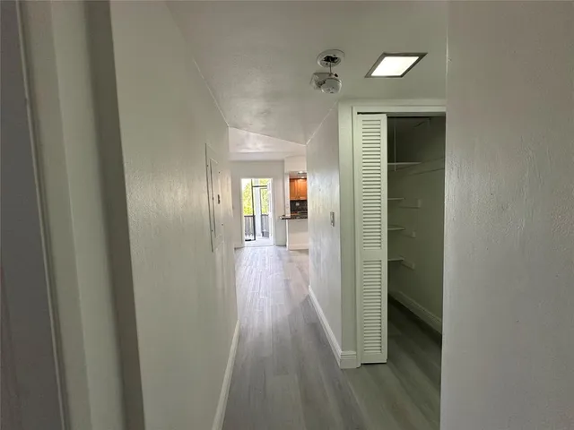a view of a hallway with wooden shelves
