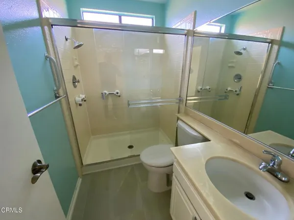 a bathroom with a sink a toilet and shower