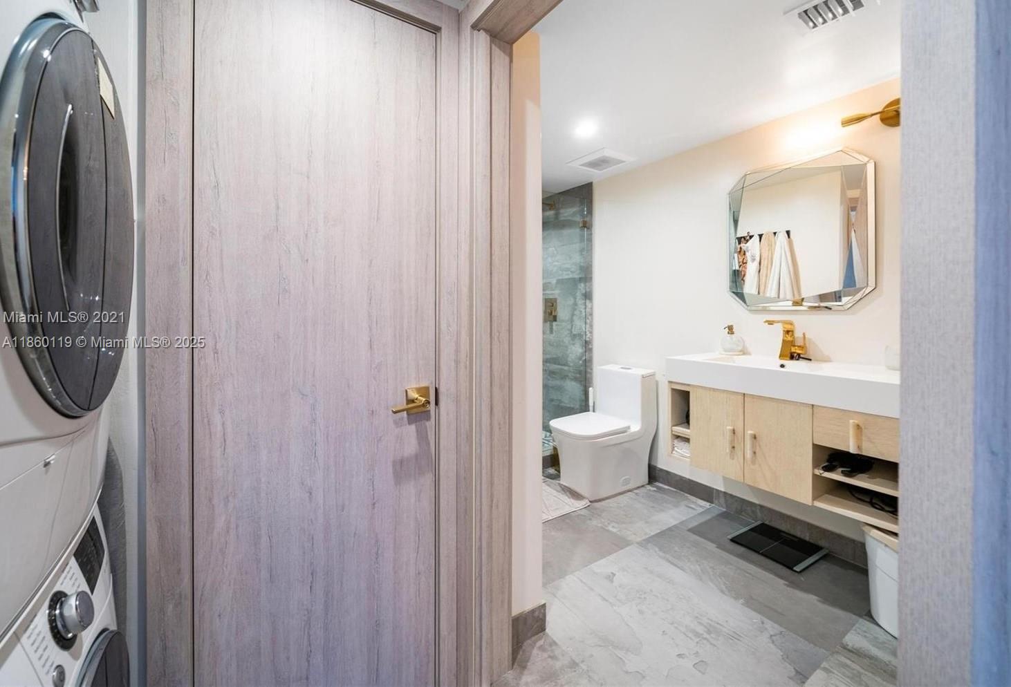 2301 Collins Avenue, Unit 306 Miami Beach, FL 33139 - Photo 11 of 27 a spacious bathroom with a toilet a sink and a mirror