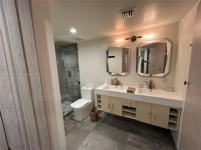 a bathroom with a double vanity sink mirror and toilet