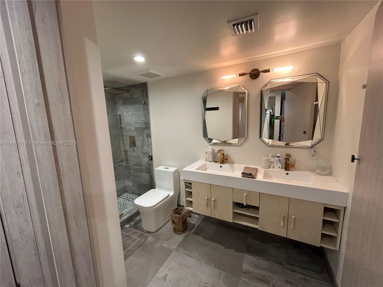 2301 Collins Avenue, Unit 306 Miami Beach, FL 33139 - Photo 12 of 27 a bathroom with a double vanity sink mirror and toilet