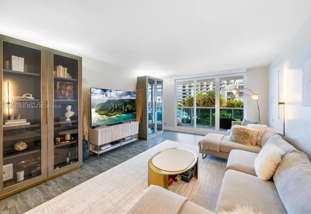 a living room with furniture a flat screen tv and a floor to ceiling window
