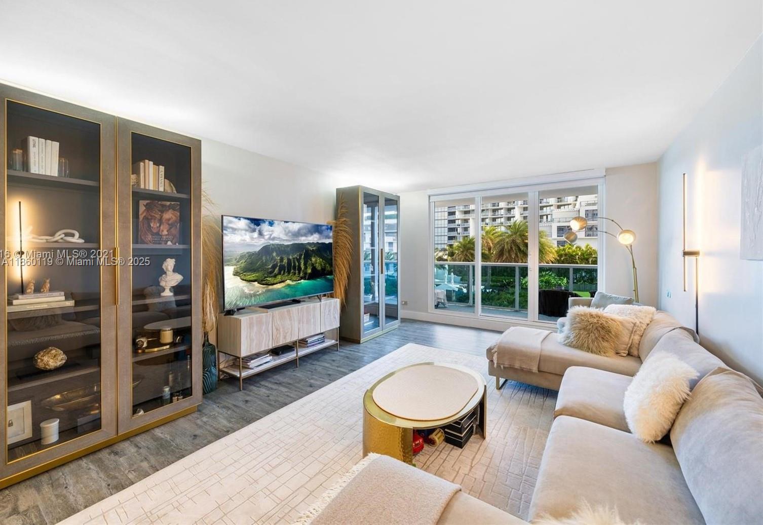 2301 Collins Avenue, Unit 306 Miami Beach, FL 33139 - Photo 3 of 27 a living room with furniture a flat screen tv and a floor to ceiling window