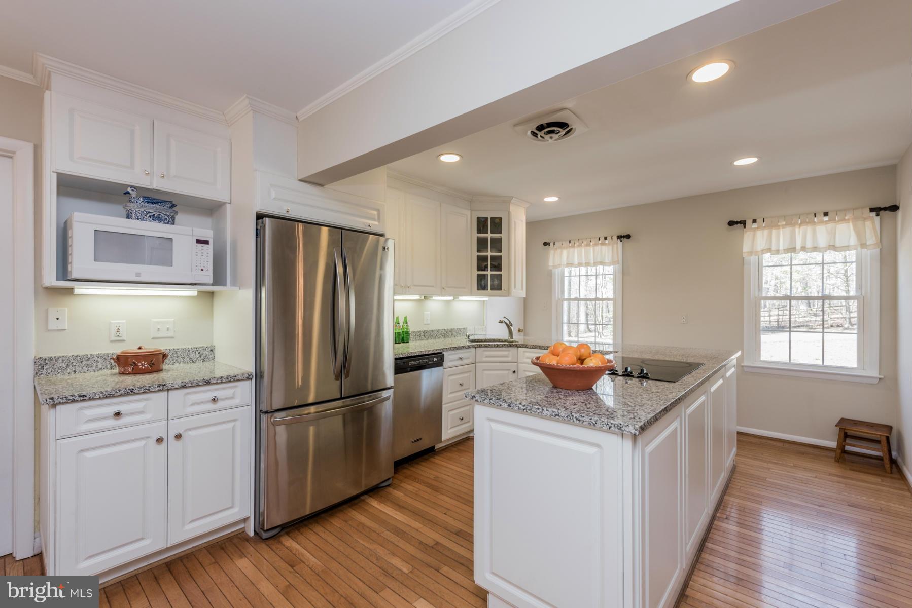 13602 Royal Crest Road Phoenix, MD 21131 - Photo 11 of 29 a kitchen with stainless steel appliances granite countertop a refrigerator a sink dishwasher a stove and white countertops with wooden floor