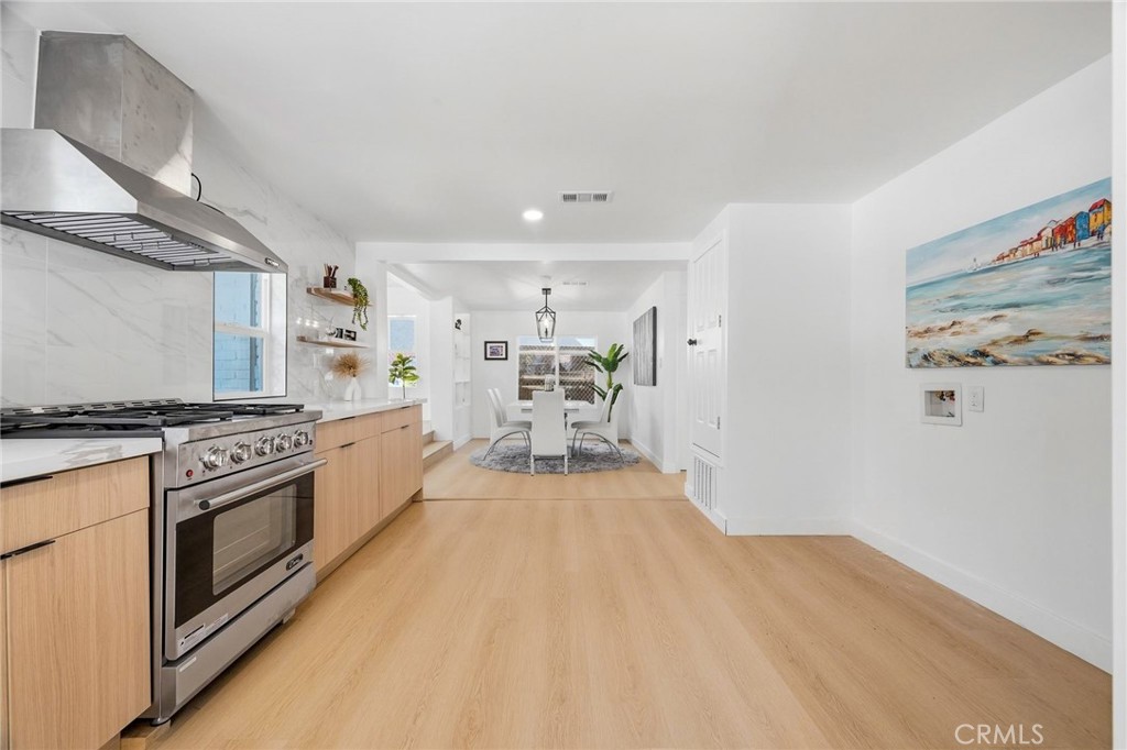 1280 East Woodbury Road Pasadena, CA 91104 - Photo 22 of 40 a large white kitchen with stainless steel appliances granite countertop a stove and a refrigerator
