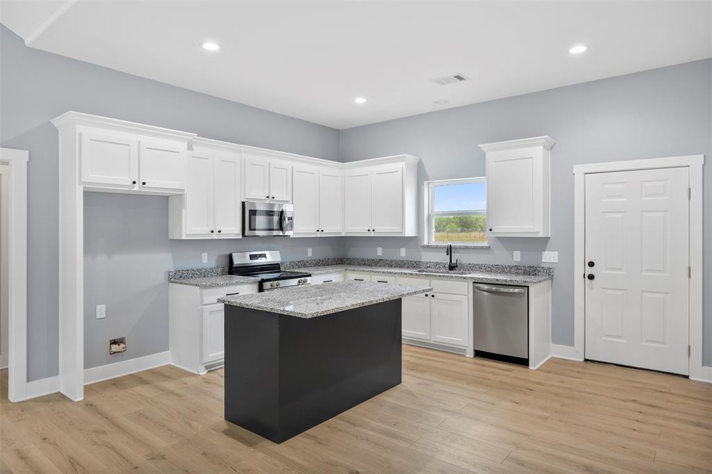 121 Brazier Road Ennis, TX 75119 - Photo 10 of 31 a kitchen with stainless steel appliances granite countertop a sink stove and refrigerator