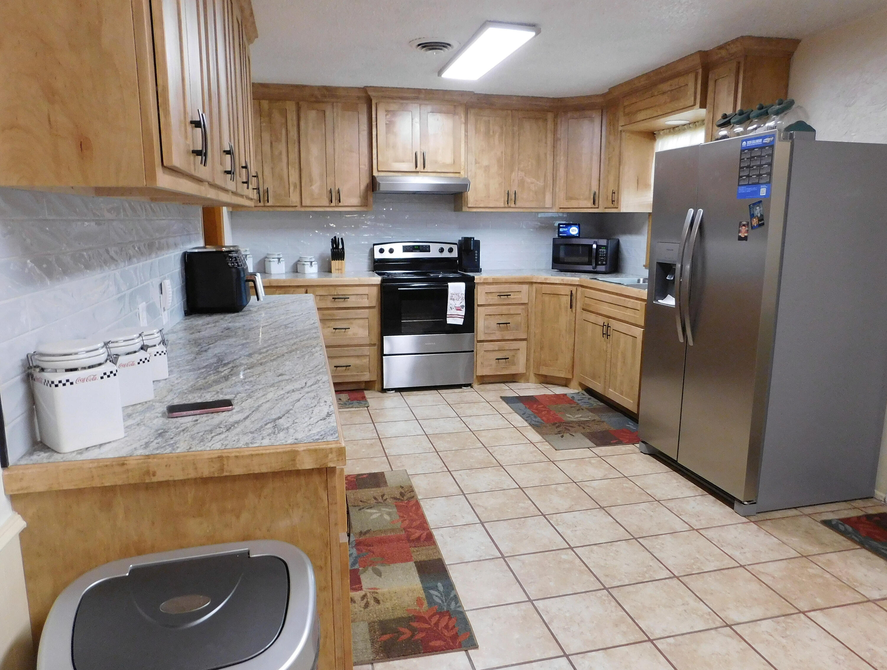 122 West 16th Street Muleshoe, TX 79347 - Photo 11 of 27 a kitchen with stainless steel appliances granite countertop a sink a stove a refrigerator and a cabinets