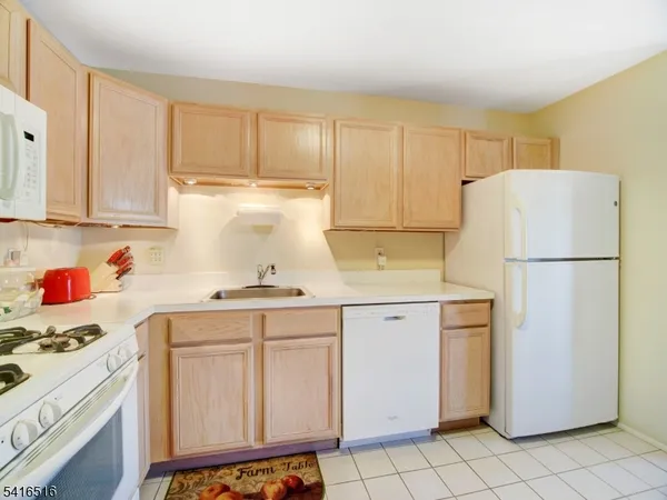 a kitchen with a refrigerator a stove a sink and cabinets