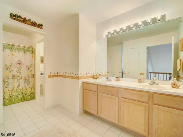 a bathroom with a double vanity sink mirror and shower