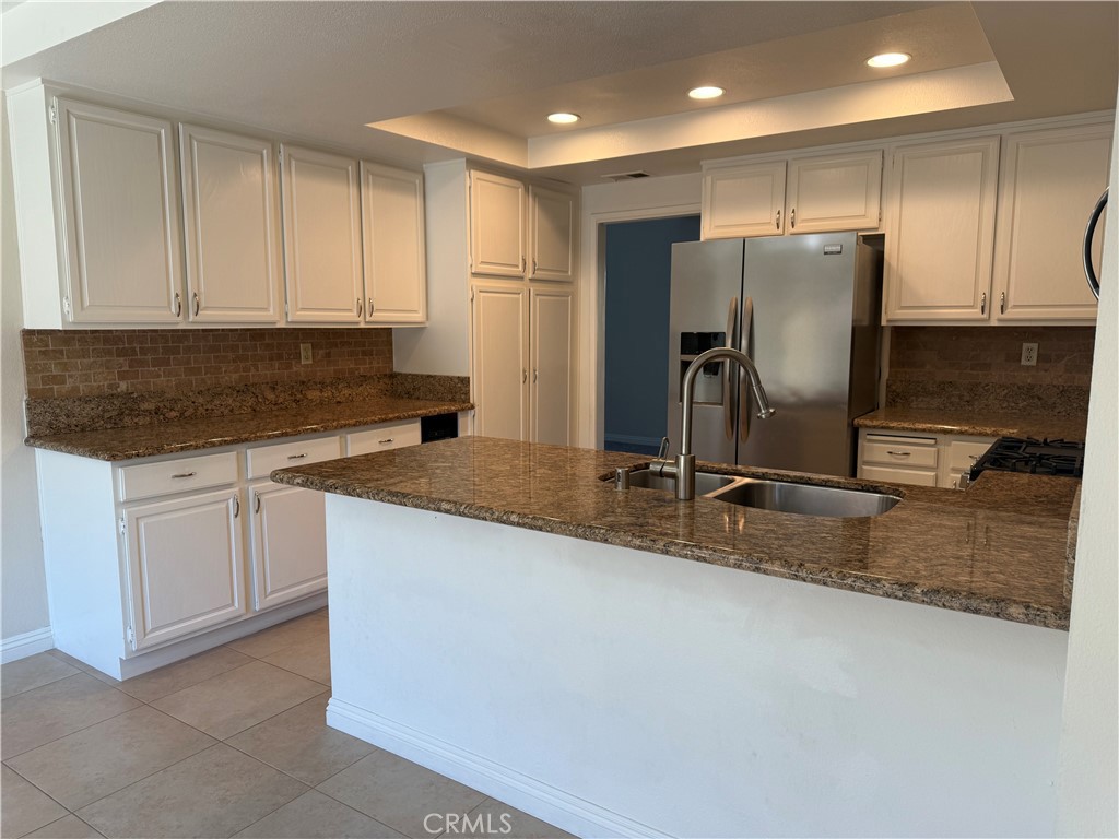 33706 Surfside Drive, Unit 146 Dana Point, CA 92629 - Photo 3 of 17 a kitchen with kitchen island granite countertop a sink a refrigerator and cabinets