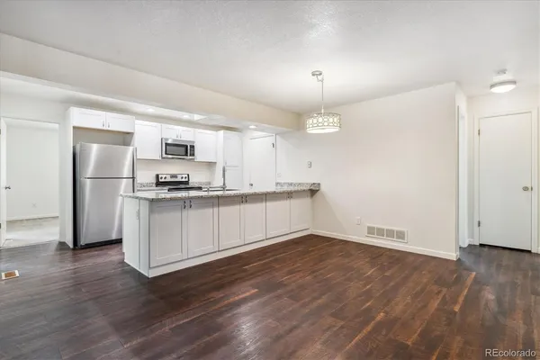 a kitchen with a refrigerator and white cabinets