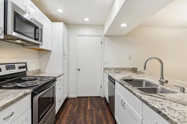 a kitchen with granite countertop a sink stainless steel appliances and cabinets