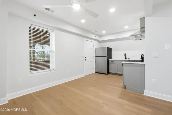 a view of a hallway with wooden floor and a bathroom