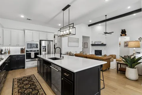 a kitchen with sink a refrigerator and chairs
