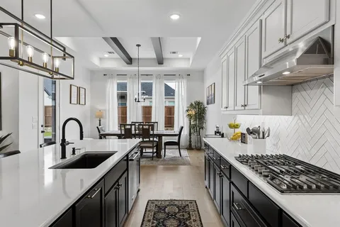 a kitchen with stove a sink and cabinets