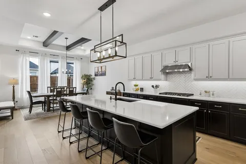 a kitchen with stainless steel appliances granite countertop a sink a stove and chairs