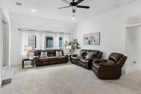 a living room with furniture and a ceiling fan