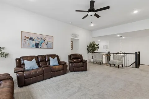 a living room with furniture ceiling fan and a rug