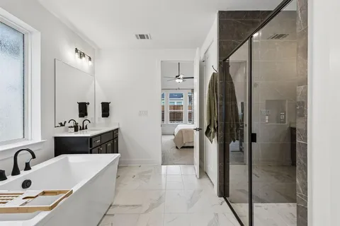 a bathroom with a tub sink shower and mirror