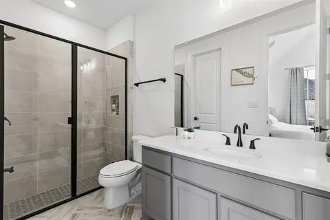 a bathroom with a sink a toilet and shower