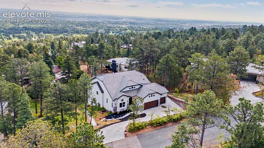 21 Leaming Road Colorado Springs, CO 80906 - Photo 6 of 48 Contemporary residence surrounded by mature pine trees, featuring a white exterior with dark trim accents