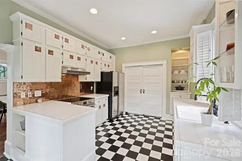 a kitchen with a sink a stove cabinets and a window