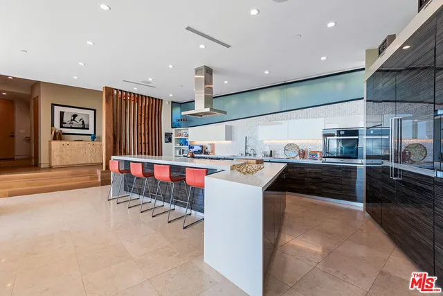 a kitchen with stainless steel appliances kitchen island granite countertop a refrigerator and a stove