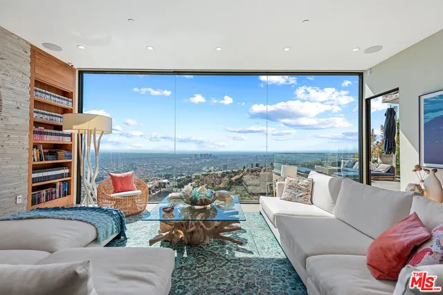 a living room with furniture and floor to ceiling window