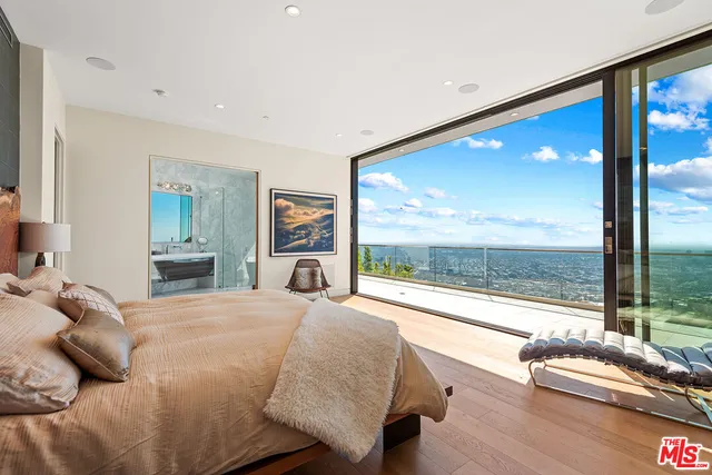 a bedroom with a bed and a large window with outer view