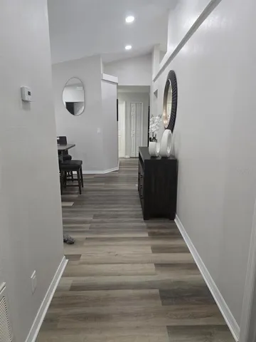 a view of a hallway with wooden floor and staircase