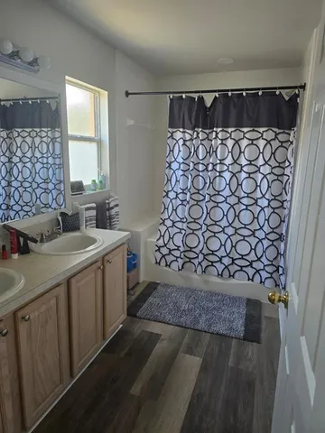 a bathroom with a granite countertop sink a toilet and shower