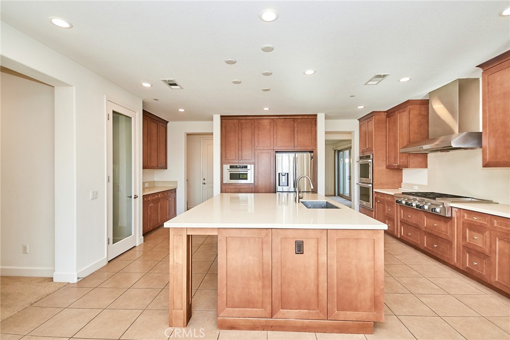 245 Snapdragon Lane Glendora, CA 91741 - Photo 21 of 42 a large kitchen with stainless steel appliances kitchen island granite countertop a refrigerator and a stove top oven