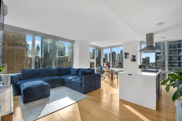 a kitchen with stainless steel appliances granite countertop table chairs stove and wooden floor