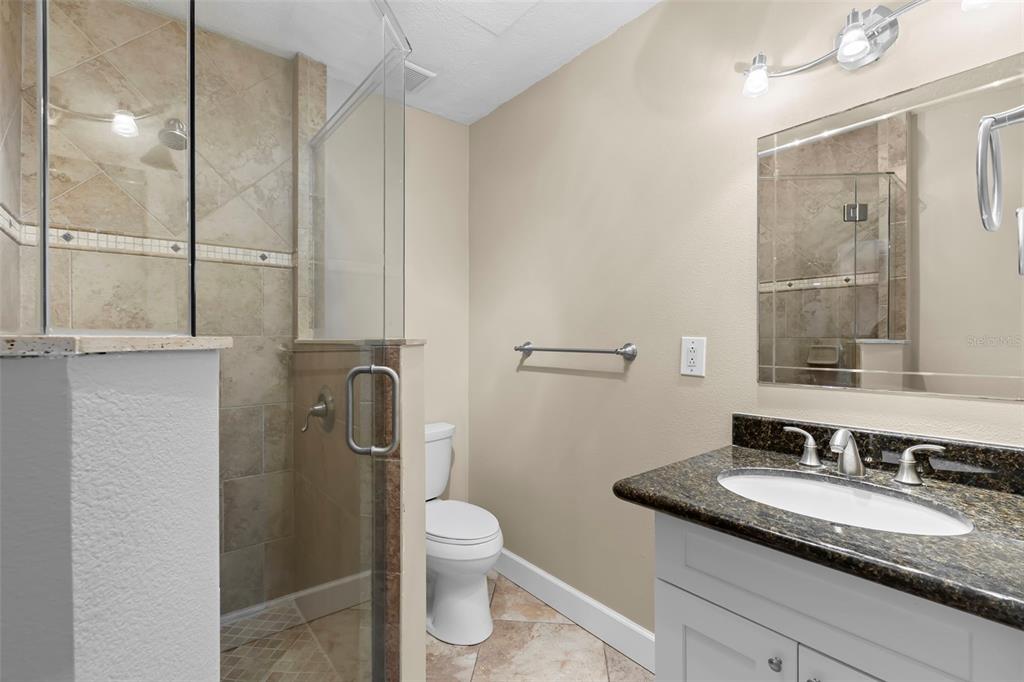 708 Sunset Cove Madeira Beach, FL 33708 - Photo 13 of 61 a bathroom with a granite countertop sink toilet and shower