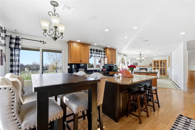 a dining room filled chandelier and wooden floor