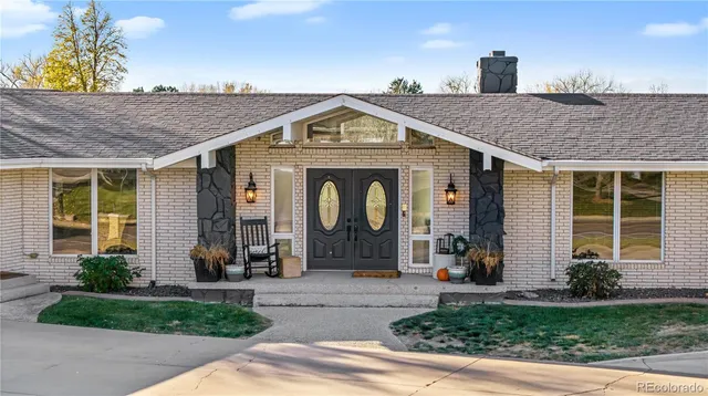 a living room with fireplace furniture and a large window