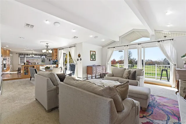 a kitchen with stainless steel appliances granite countertop a refrigerator a sink dishwasher a dining table and chairs with wooden floor