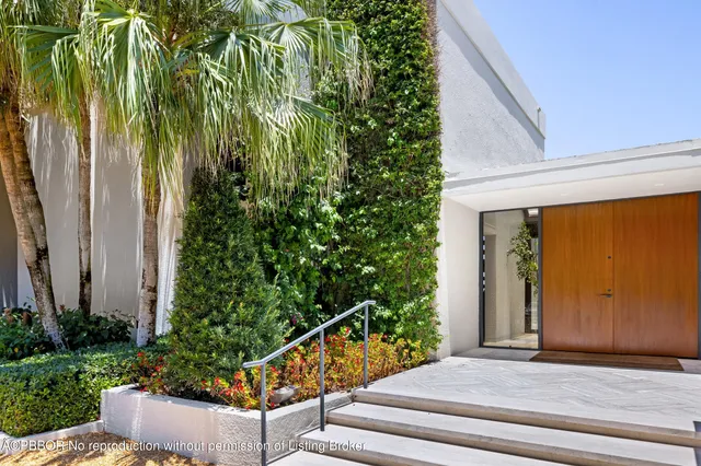 a view of a house with a big yard and large trees