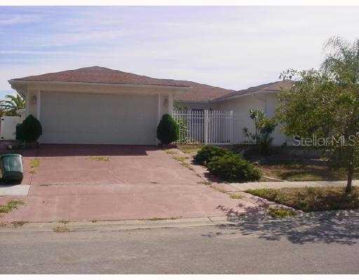 8832 Martinique Lane Port Richey, FL 34668 - Photo 1 of 1 a front view of a house with a yard and a garage