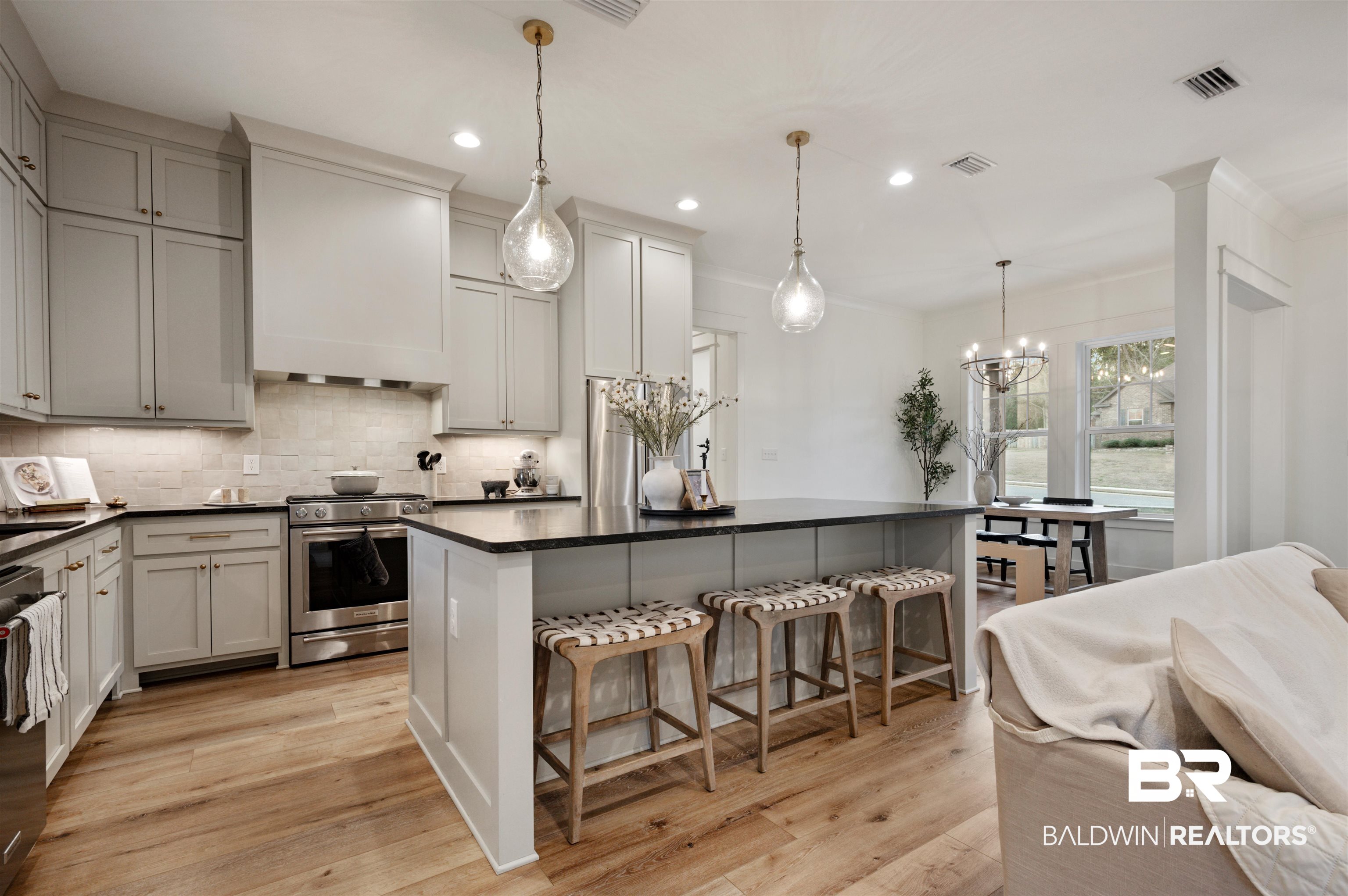 312 Pecan Ridge Boulevard Fairhope, AL 36532 - Photo 11 of 43 Kitchen with light wood-type flooring, stainless steel gas range, gray cabinets, and pendant lighting