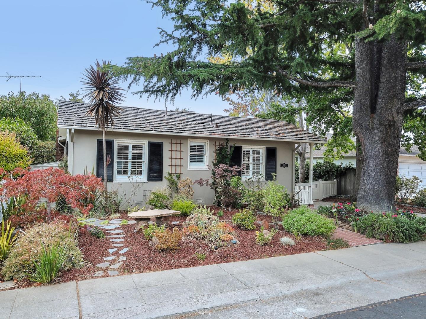 front view of house with a yard and potted plants