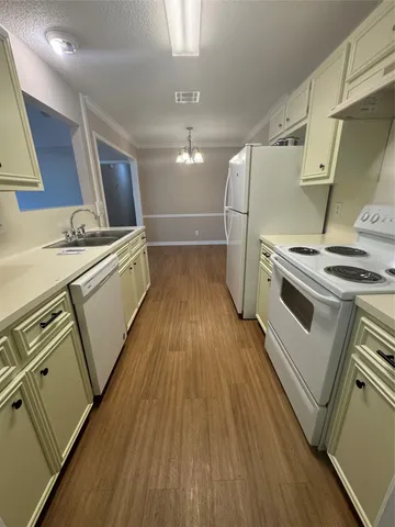 a kitchen with wooden floors and appliances
