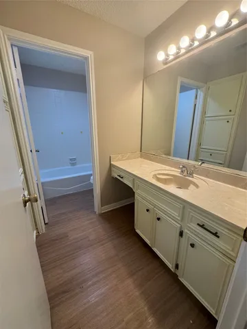 a spacious bathroom with a granite countertop sink and a mirror