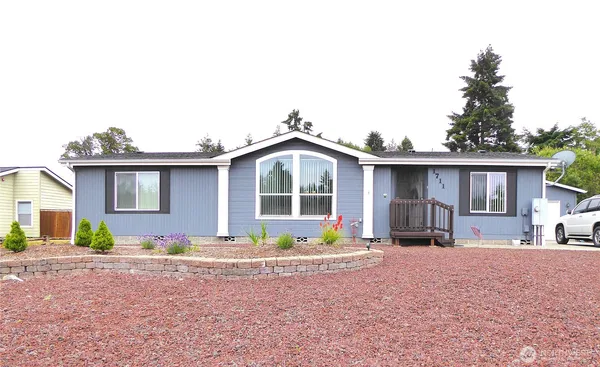 a front view of a house with a yard and seating space