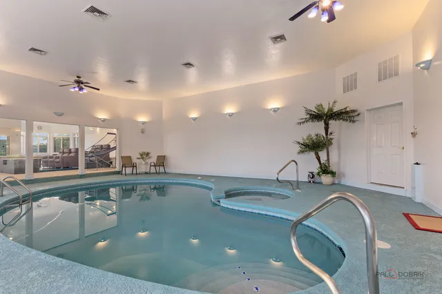 a view of a kitchen with kitchen island a sink stainless steel appliances and living room
