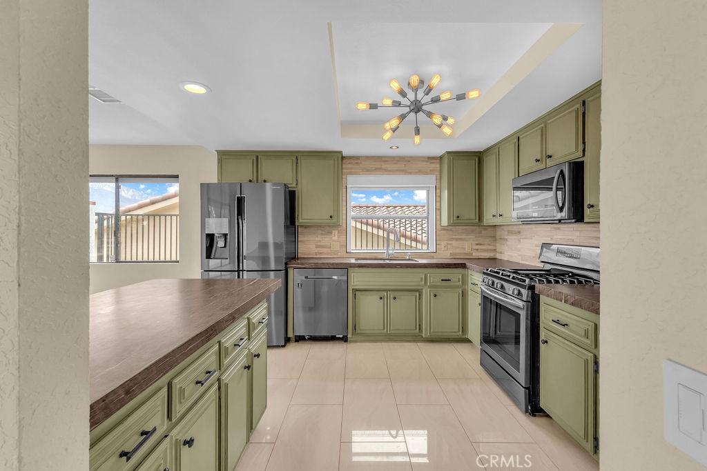 67525 Monterey Road Desert Hot Springs, CA 92240 - Photo 14 of 75 a kitchen with stainless steel appliances granite countertop a stove a sink and a microwave