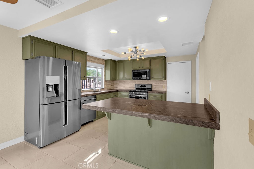 67525 Monterey Road Desert Hot Springs, CA 92240 - Photo 19 of 75 a kitchen with stainless steel appliances granite countertop a sink a refrigerator and a granite counter tops