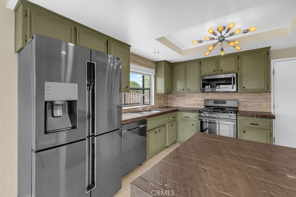 67525 Monterey Road Desert Hot Springs, CA 92240 - Photo 20 of 75 a kitchen with granite countertop stainless steel appliances and a refrigerator