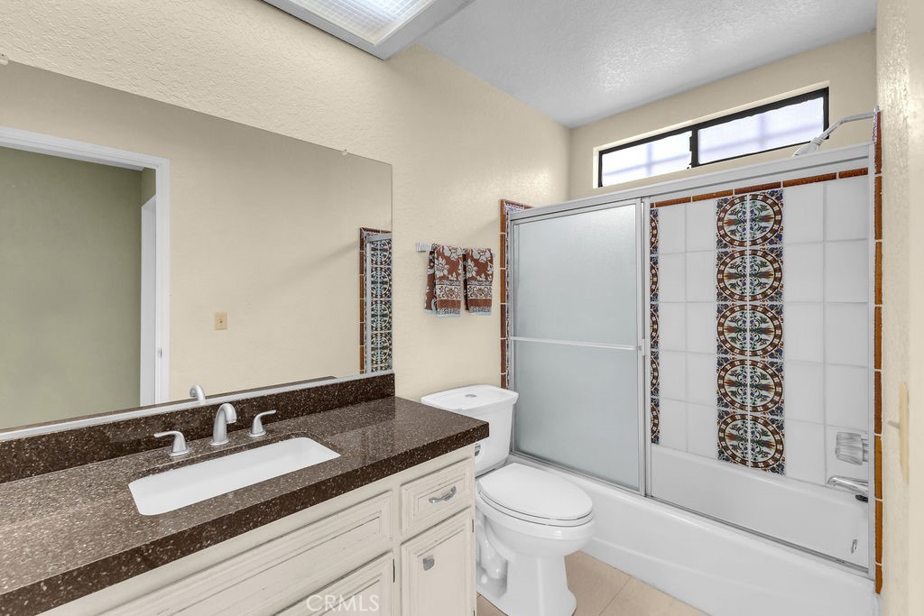 67525 Monterey Road Desert Hot Springs, CA 92240 - Photo 31 of 75 a bathroom with a granite countertop sink toilet and shower
