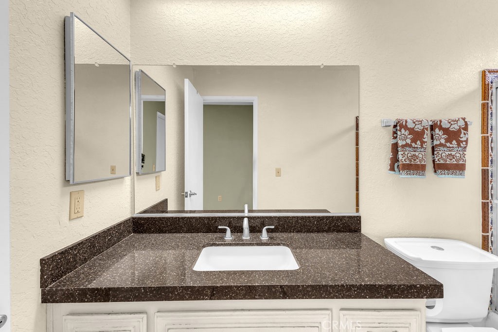 67525 Monterey Road Desert Hot Springs, CA 92240 - Photo 32 of 75 a bathroom with a granite countertop sink and a mirror